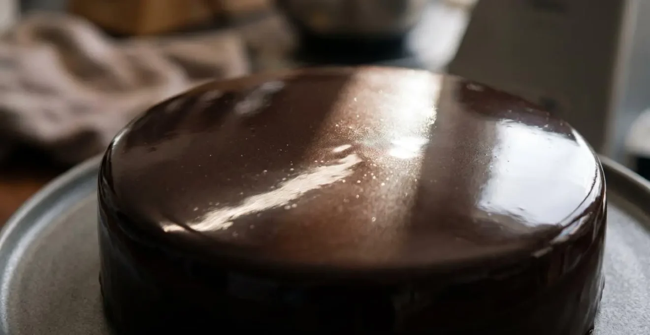 Réflexion spéculaire de la lumière sur un glaçage miroir au chocolat montrant sa surface parfaitement lisse