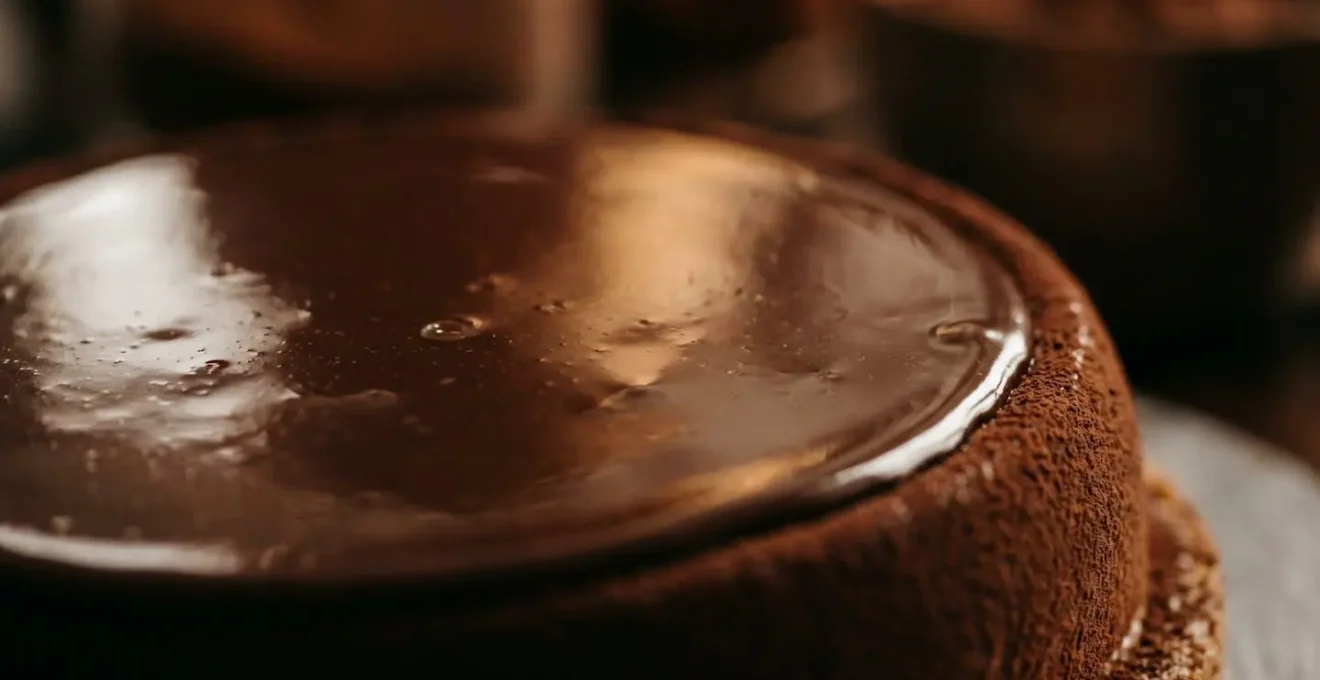 Détail macro de la texture lisse et brillante d'un glaçage miroir au chocolat parfaitement réussi